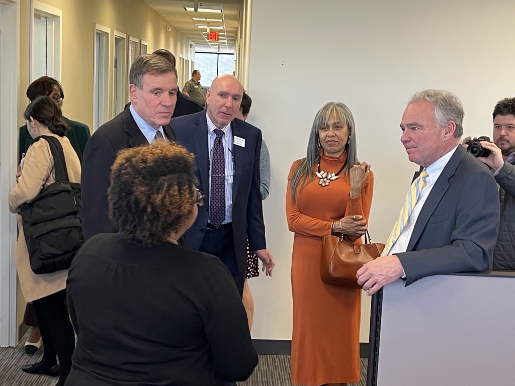 Senators Kaine and Warner listening to a woman talk in a small group