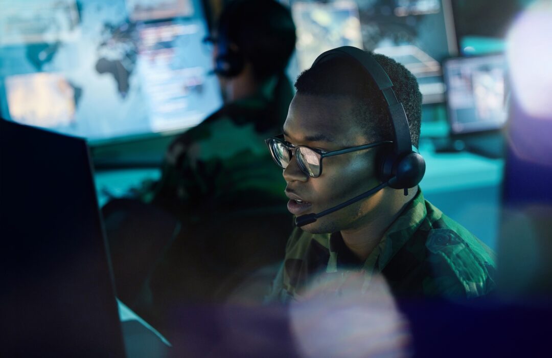 Military control room, computer and man with headset, support or tech for communication. 