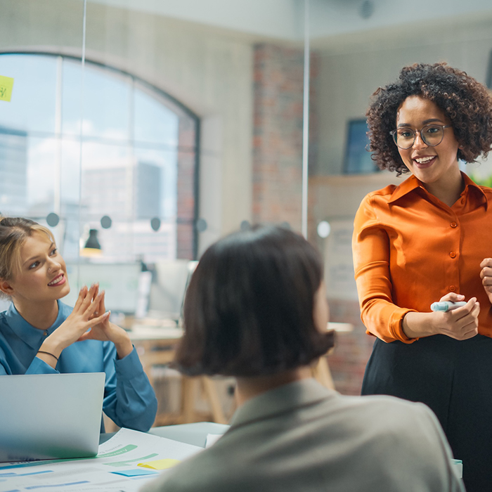 Woman talking to two other women in office